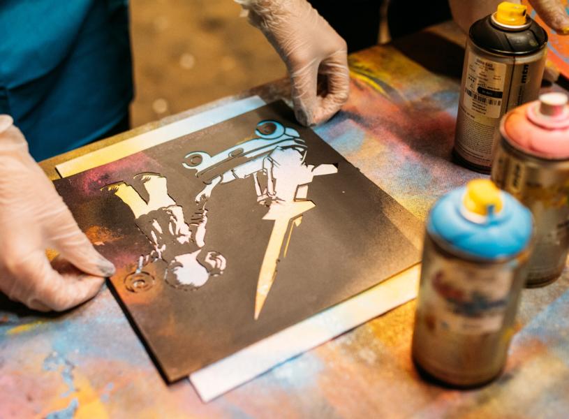 A person lining up a canvas before spraying paint at Graft Bristol - credit Yuup