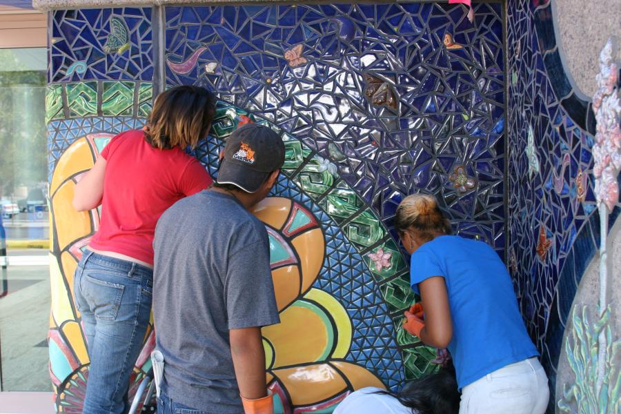 Artists working on convention center tile mural