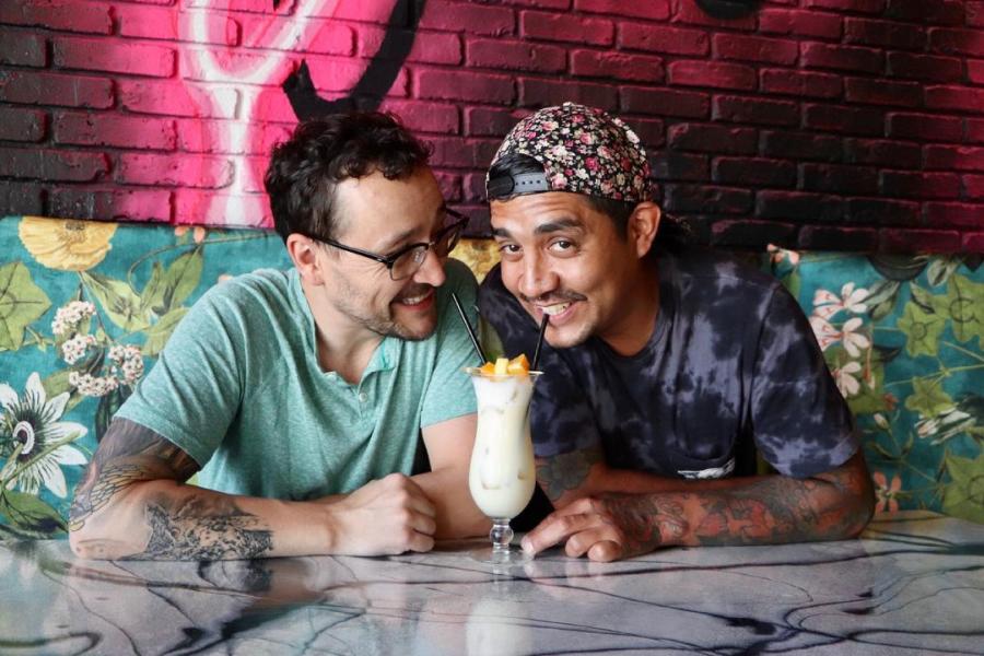 Two men sip from a drink at Happy Accidents bar in Albuquerque