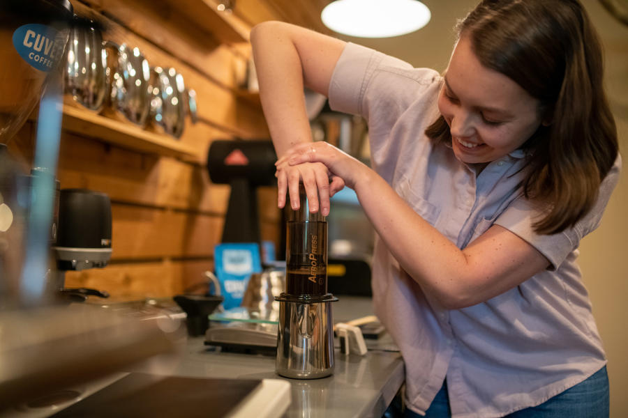 Student presses coffee at Texas Coffee School's Coffeepreneurs® class