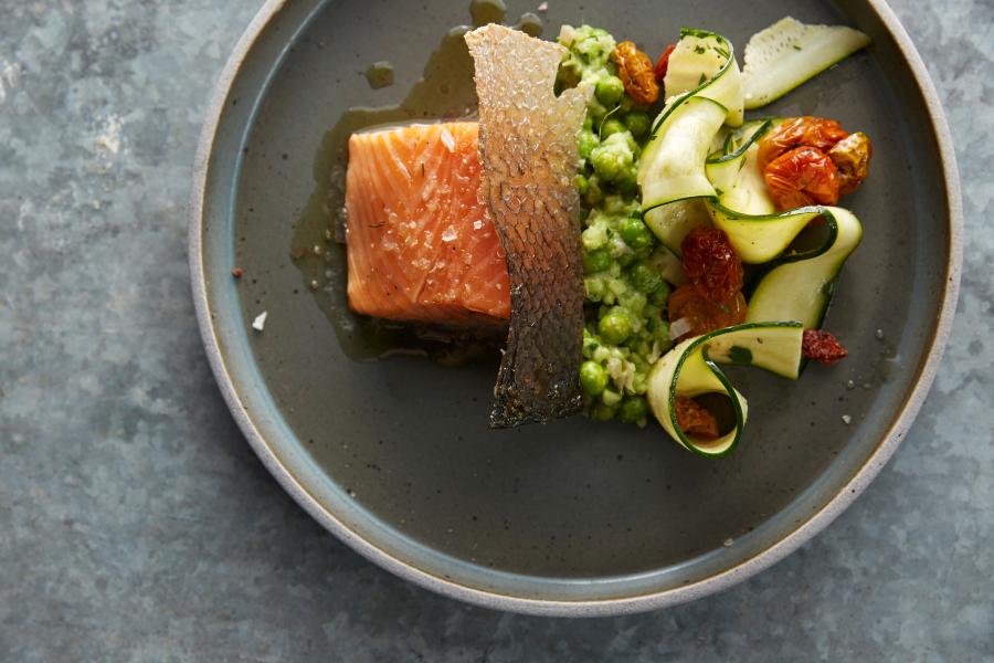 Beautifully plated salmon, with green veggies and a sauce