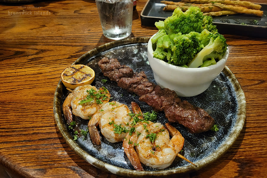 a plate with skewered shrimp and beef kebab and a side of broccoli from Angus Steak and Seafood in Calabash, NC