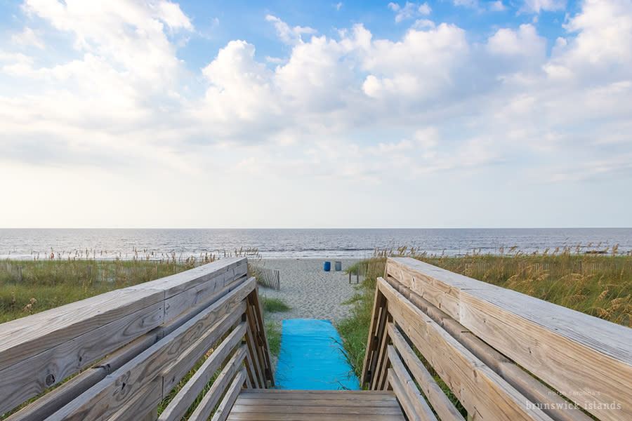 a wooden walkway with steps and a mobi-mat leading onto Holden Beach