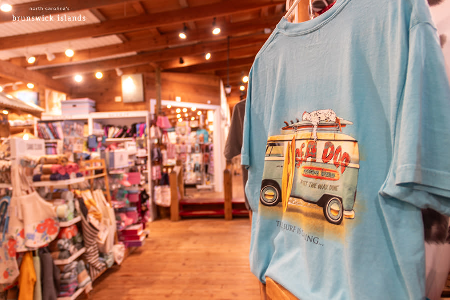 a t shirt on sale at callahans of calabash with a view of other apparel in the background