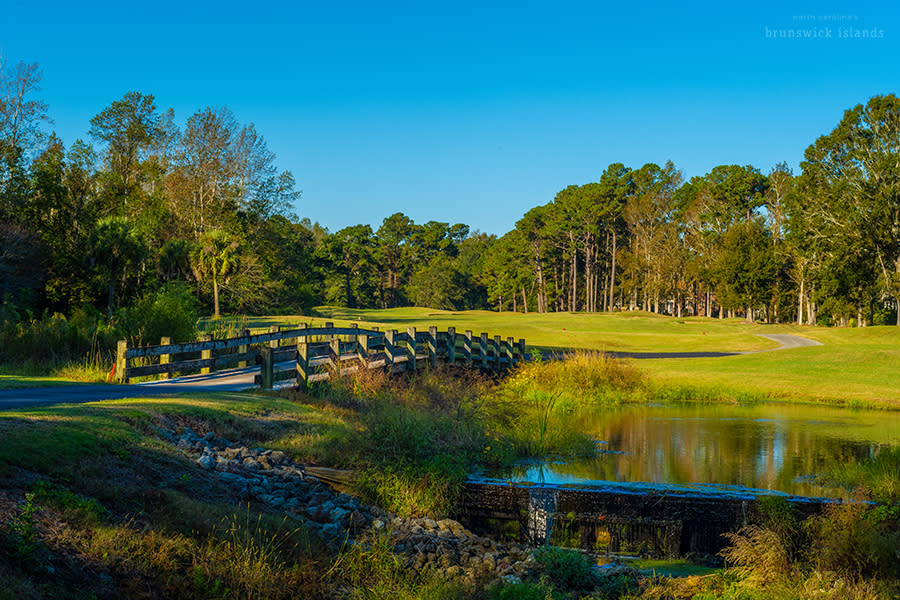 a view of a wooden bridge leading to a green on a hole of the Lion's Paw Golf Links