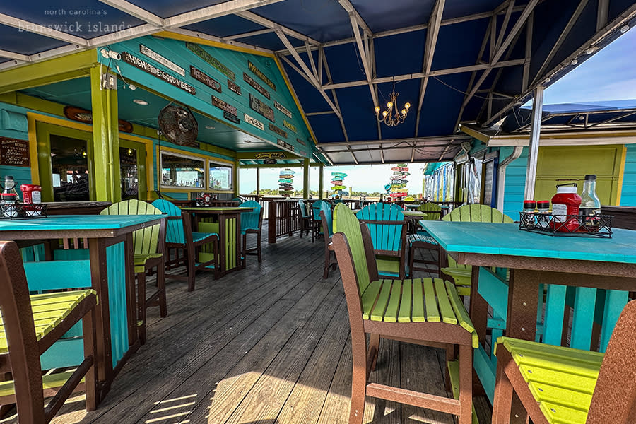 a covered outdoor patio at Fishy Fishy Cafe with bright green chairs and tables