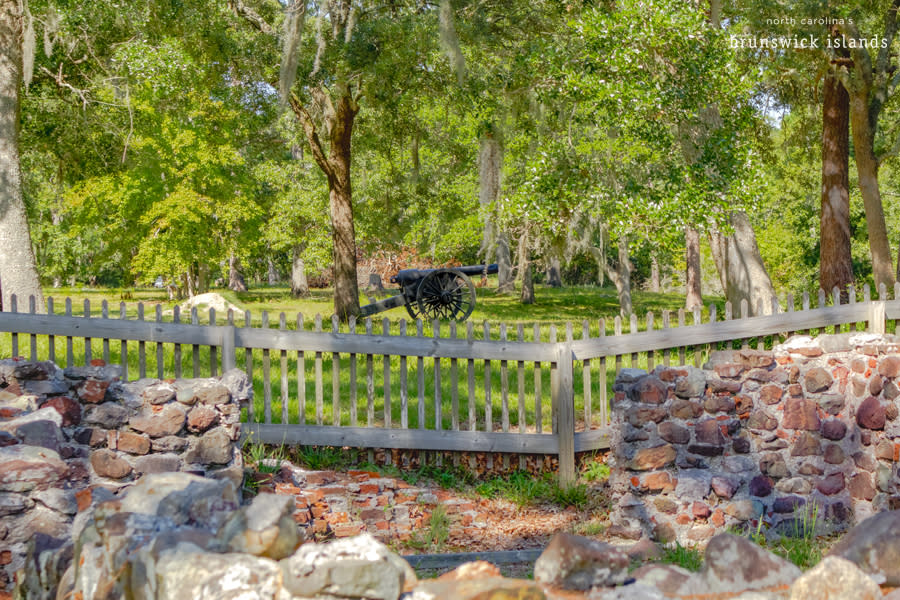 view of a canon sitting in a clearing with brick ruins in the foreground