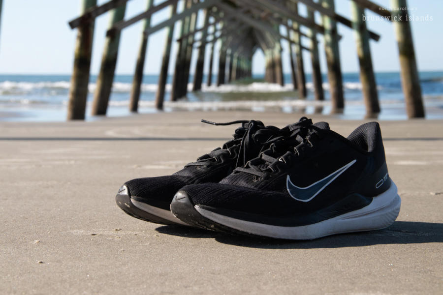a pair of black running shoes on the beach