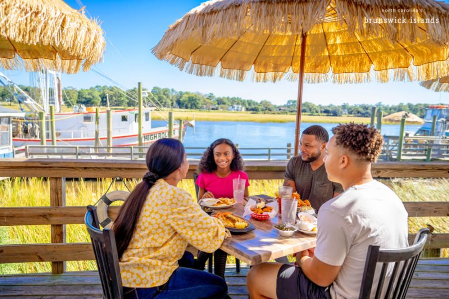 a family eating seafood outside along a waterway