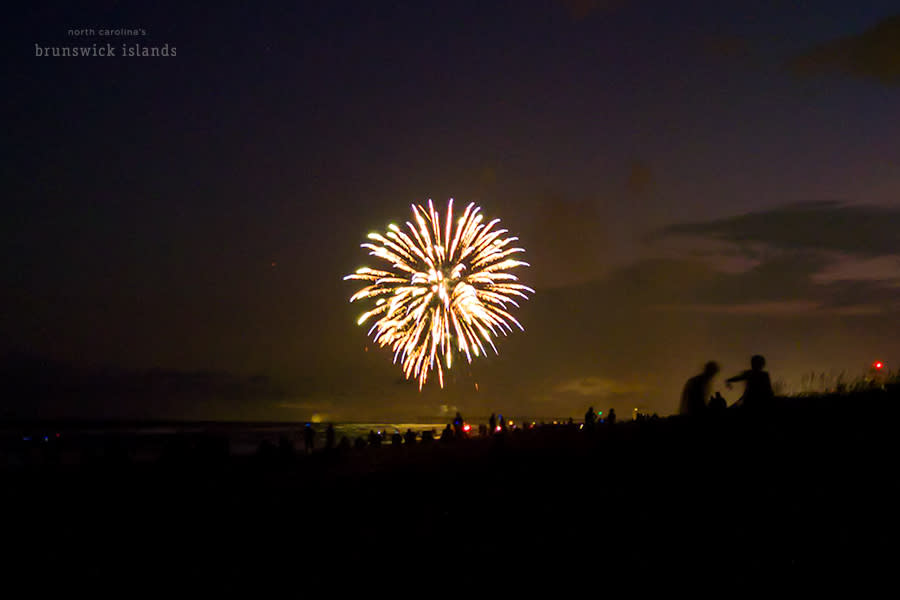 a golden firework display over the ocean visible from the beach on Ocean Isle Beach, NC