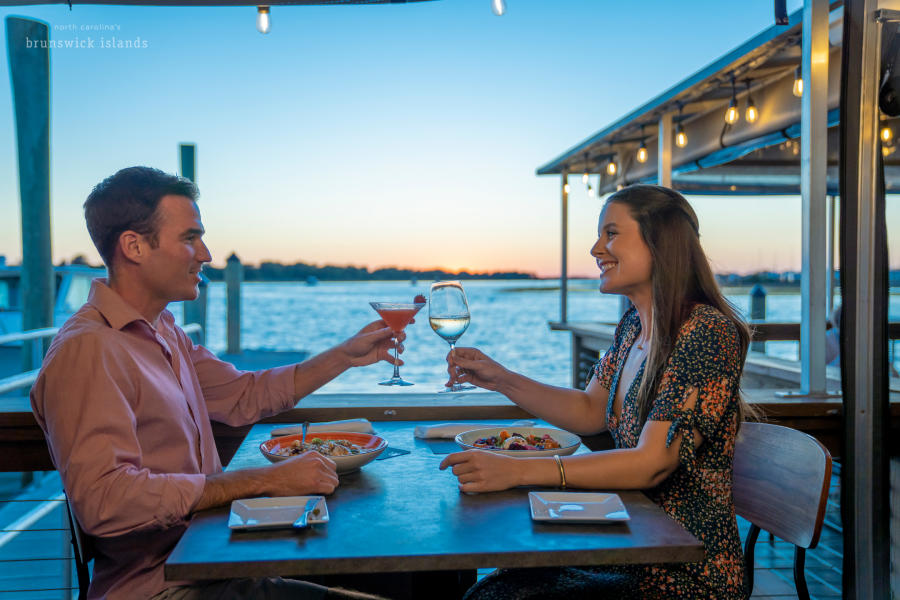 a couple toasting over a meal