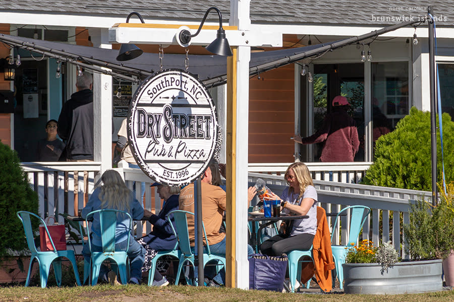 an exterior view of a pizza shop with outdoor seating - Dry Street Pub & Pizza