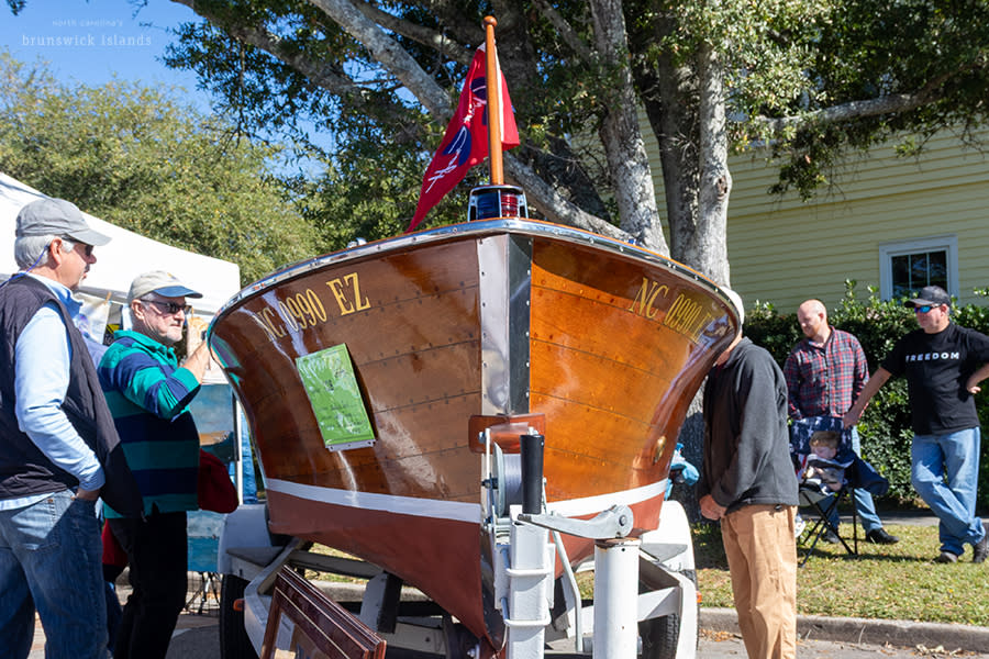 a wooden boat displayed out of water at the Southport Wooden Boat Show
