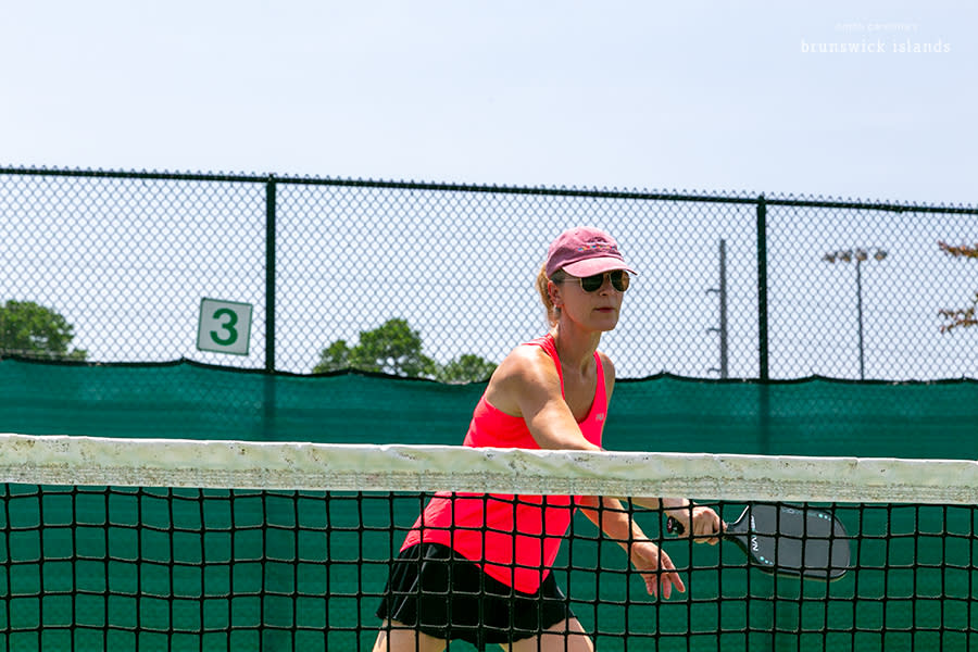 a woman waiting to return a pickleball hit