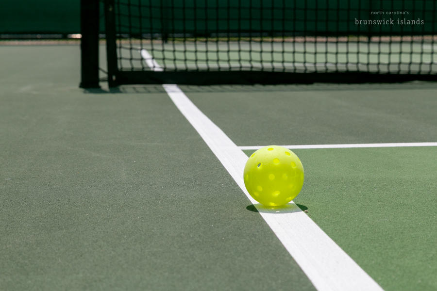 a pickleball sitting on the court line