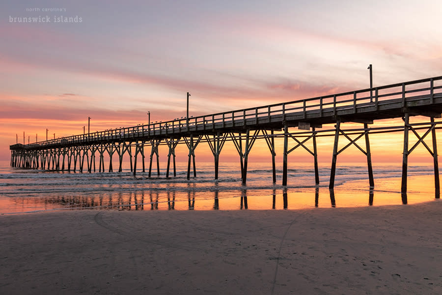 Sunset Beach pier with a sky full of vivid pink, reds, purple, and orange light after sunset