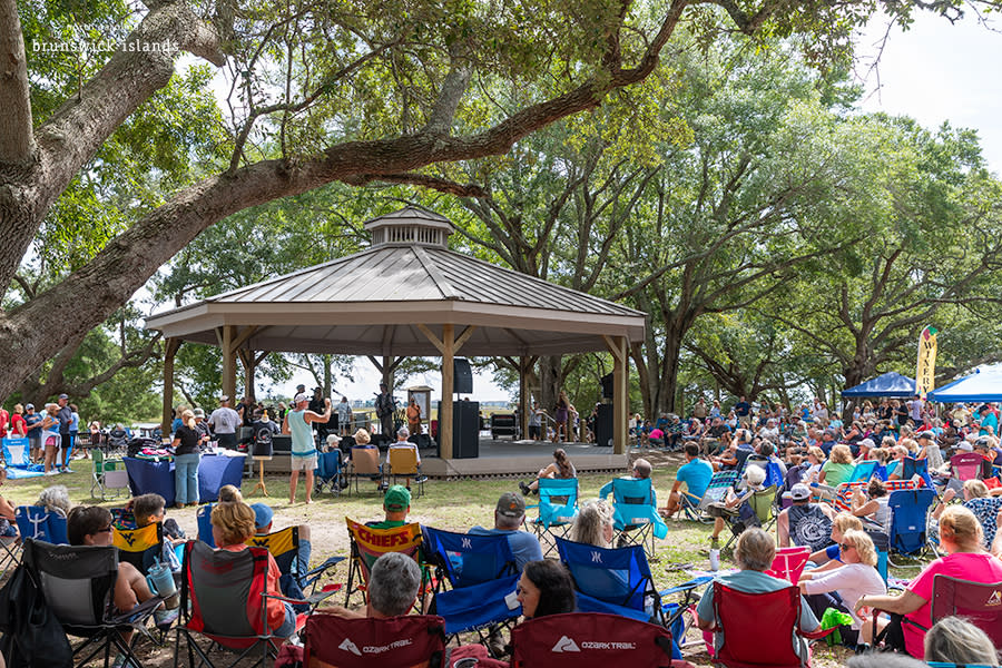 a group of people listening to an outdoor concert in Sunset Beach Town Park
