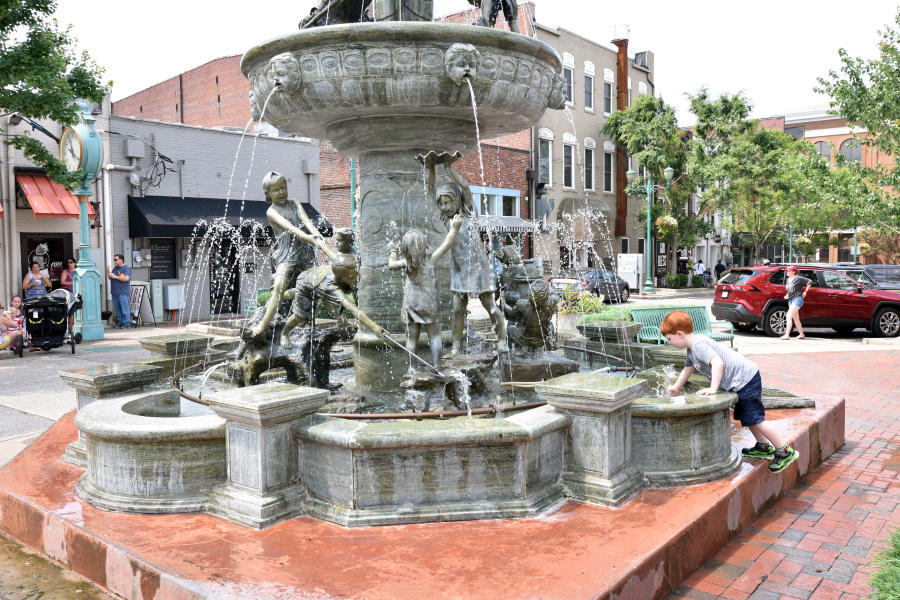 boy playing in fountain