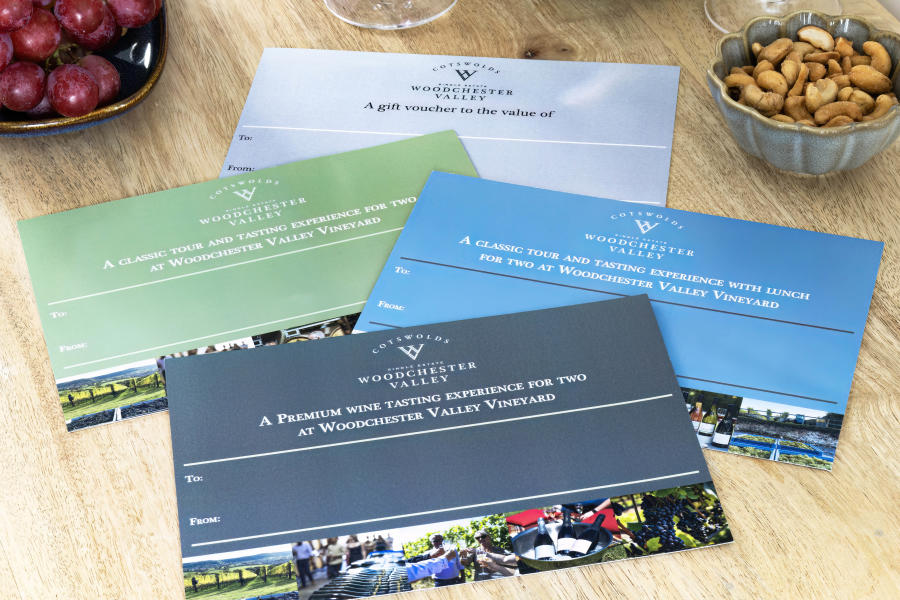 Woodchester Valley Vineyard vouchers with a bowl of nuts and the stem of a wine glass visible in the background