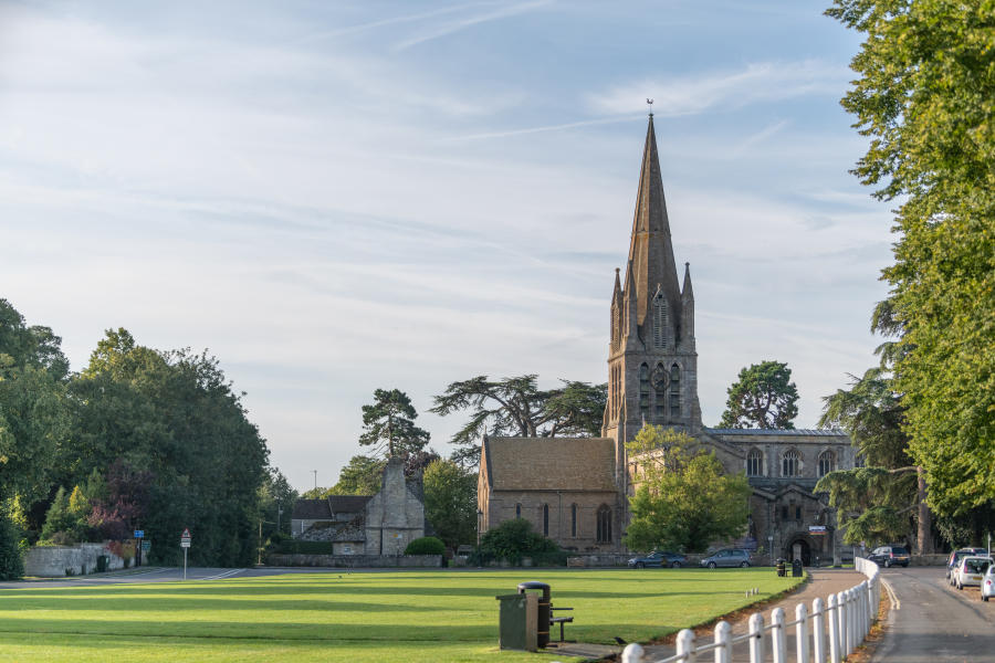 St Mary's Church in the distance with blue sky and the Church Green in the foreground.
