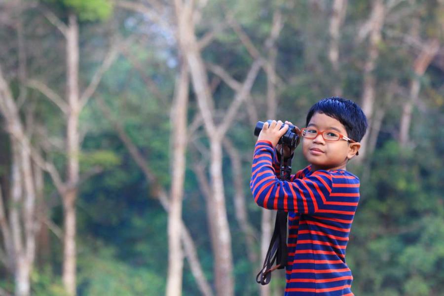 little boy taking a break from bird watching