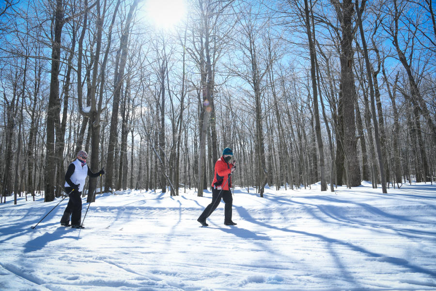 A man and woman cross country ski on Bristol Mountain's nordic trails