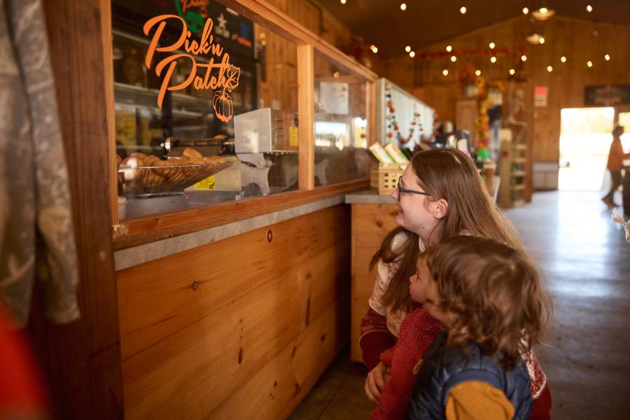 Family looking at cider donuts at a barn at Pick'N Patch.