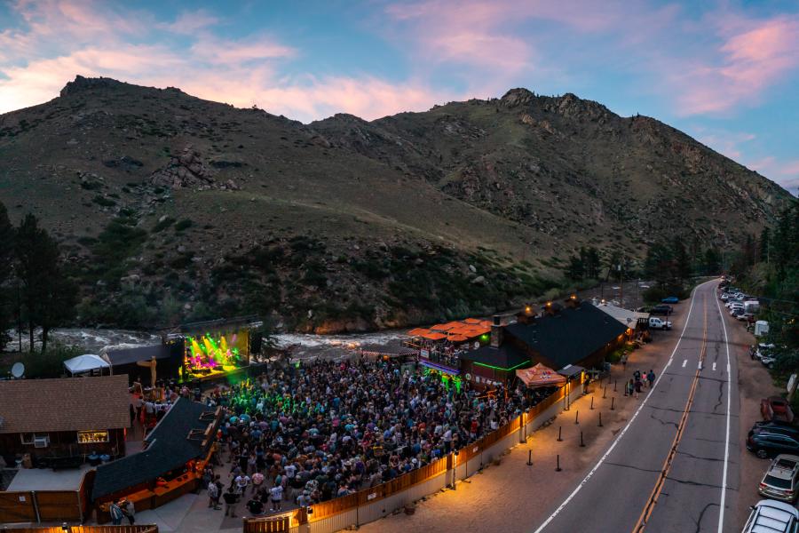 An ariel view of 1,000 people attending a mishawaka concert with the Poudre Highway on one side of the venue and the Poudre River on the other side of the venue.