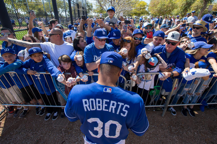 Baseball player signs autographs for fans