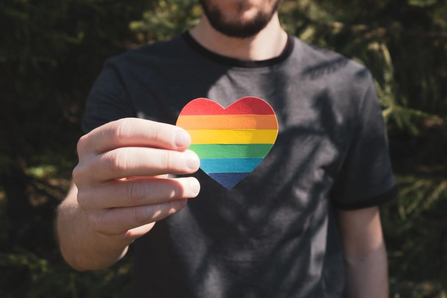 Person holding a rainbow heart