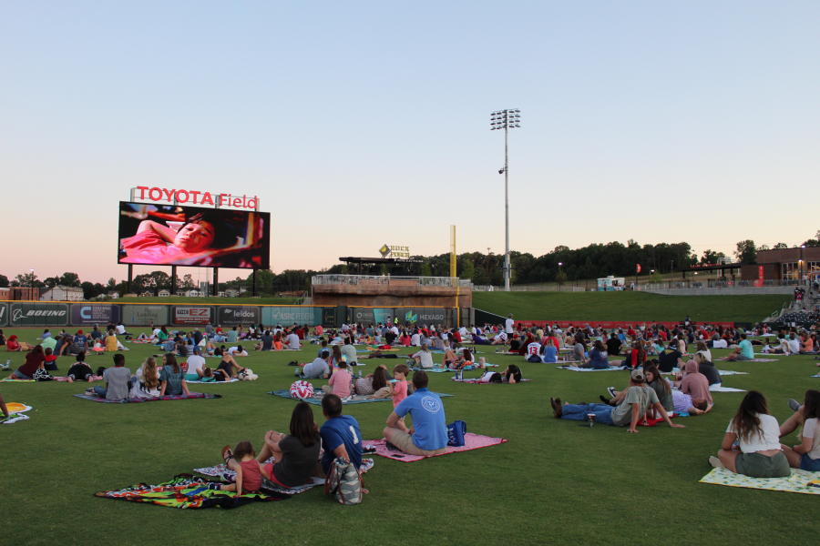 People enjoy a social-distance movie night in the Toyota Field outfield.