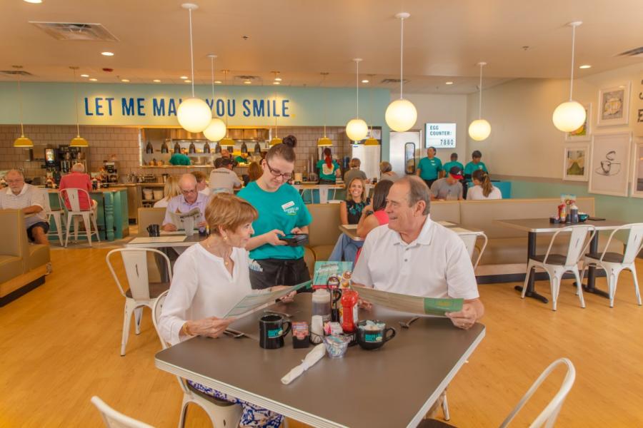 Two older people ordering food at Eggs Up Grill