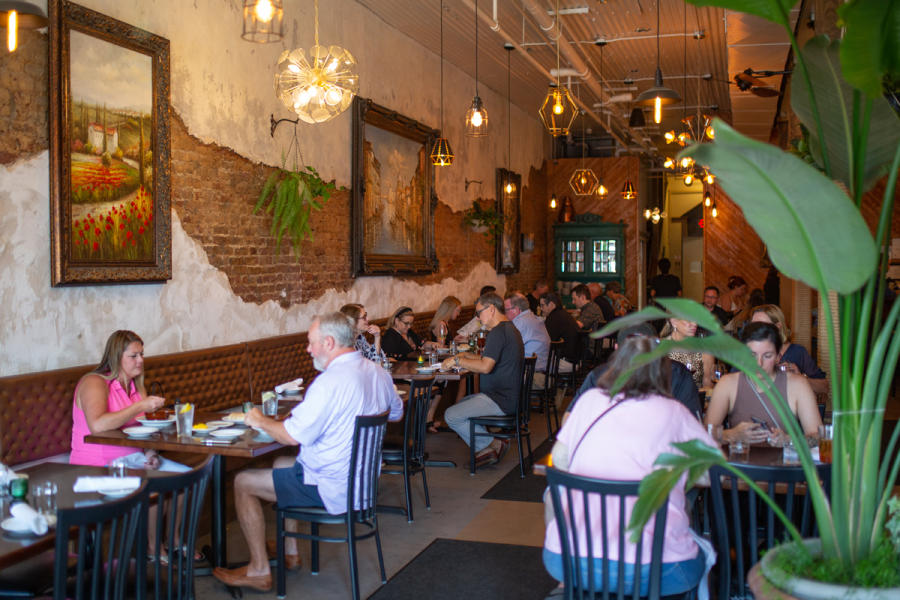 a restaurant with rows of tables and people sitting eating
