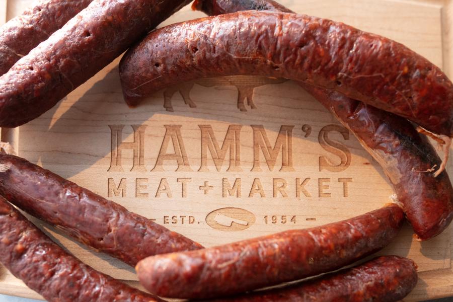 Cutting board engraved with Hamm's Meat + Market surrounded by sausage links