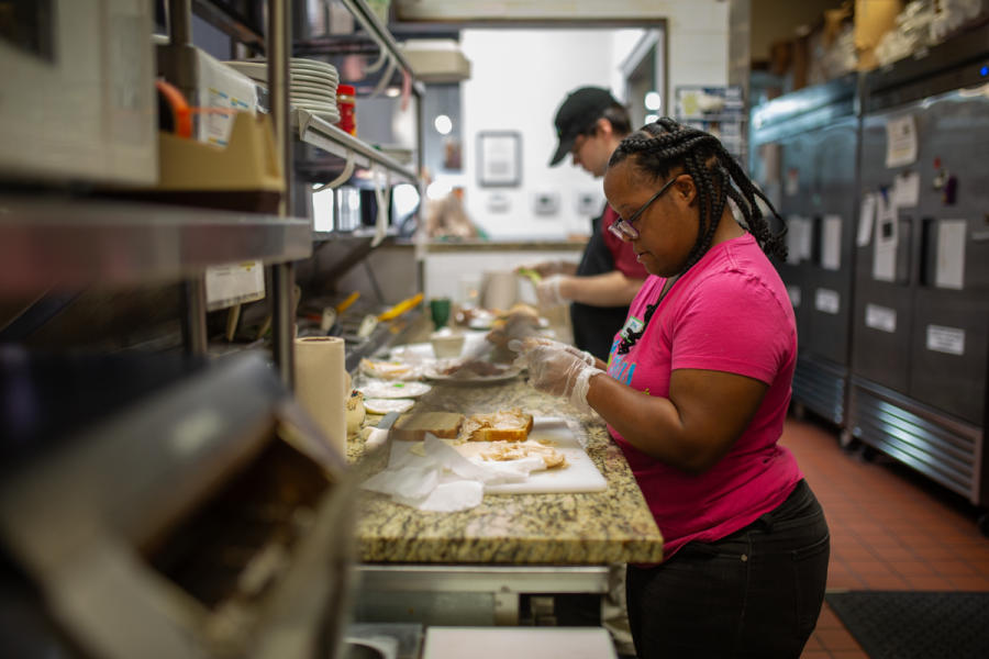 young man and woman in commercial kitchen making sandwiches