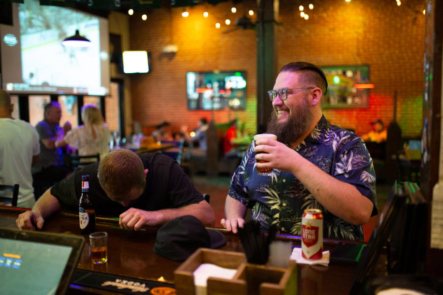 The Pub - two men sitting at the bar with drinks laughing