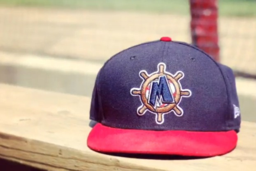 Blue and Red Muskegon Clippers baseball Hat sits on wooden bench