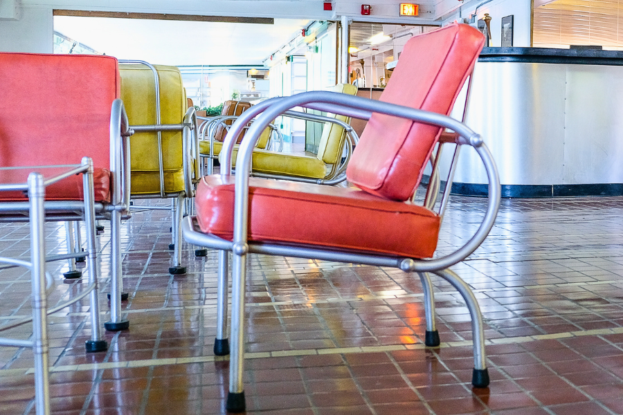 tubular steel warren mcarthur art deco chair with coral cushions sits in lounge of ss milwaukee clipper museum ship