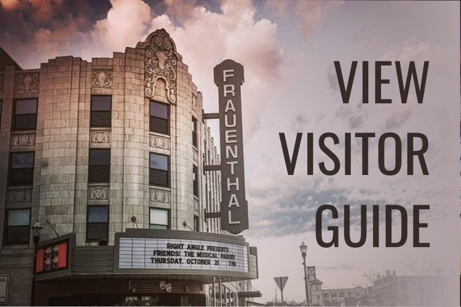 Historic theater facade under dramatic clouds displays "Frauenthal" sign. Marquee shows event details. Large text reads "View Visitor Guide."