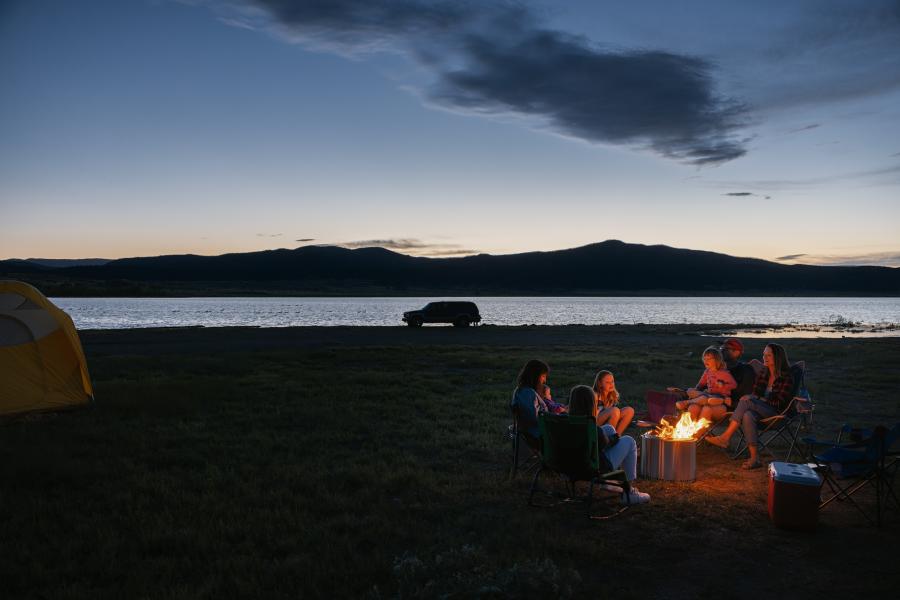A family sits around the campfire on the banks of Storrie Lake State Park in Las Vegas, New Mexico.