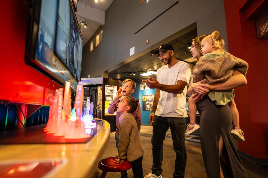 Family watching a family-friendly science exhibit at the Bradbury Museum in Los Alamos, New Mexico