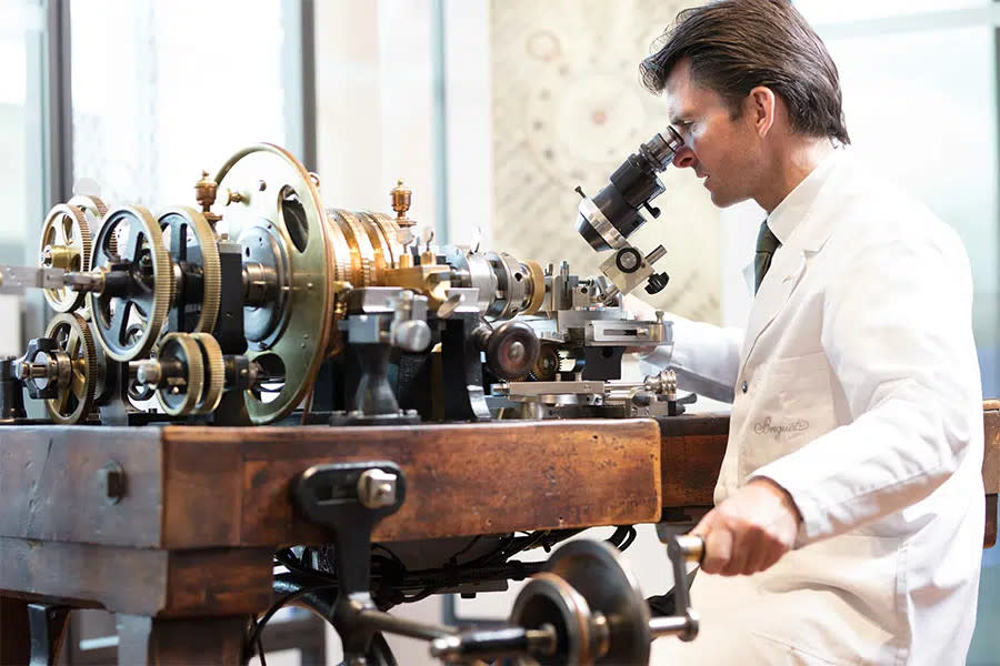 An artisan at Breguet uses a traditional machine for guilloché