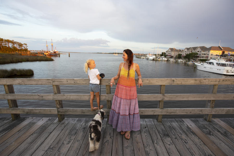Mother and daughter with their dog on a wooden bridge