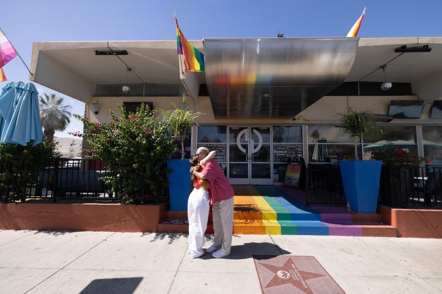 Two people hugging in front of Hunters Palm Springs