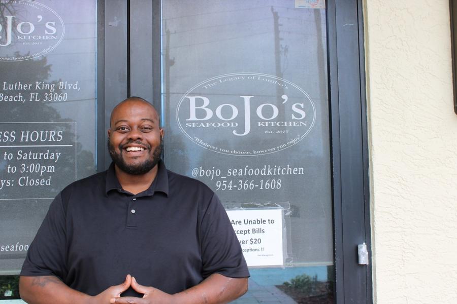 The owner of Bo Jo's Seafood Kitchen standing in front of the front door of his restaurant