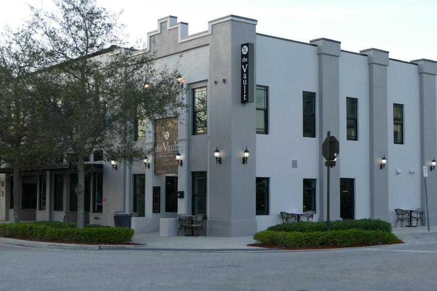The exterior of The Vault, a two-story, two-toned grey corner building