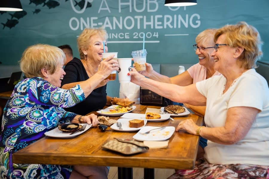 A group of four older women, enjoying a meal and each other's company at How You Brewin' Coffee Company in Pompano Beach.