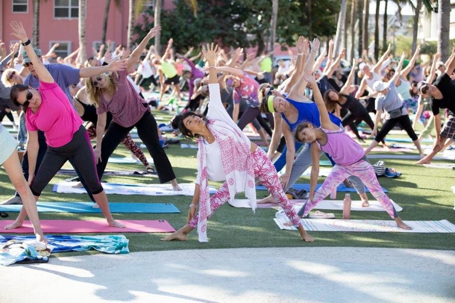 A large group doing yoga on the Great Lawn of Pompano Beach