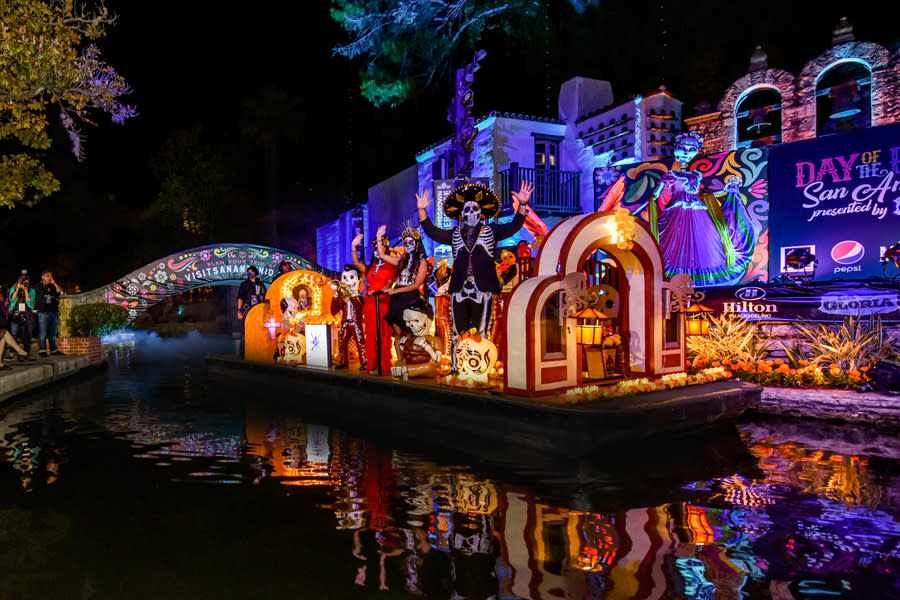 Nighttime river parade with parade float decorated with Dia de los Muertos decor
