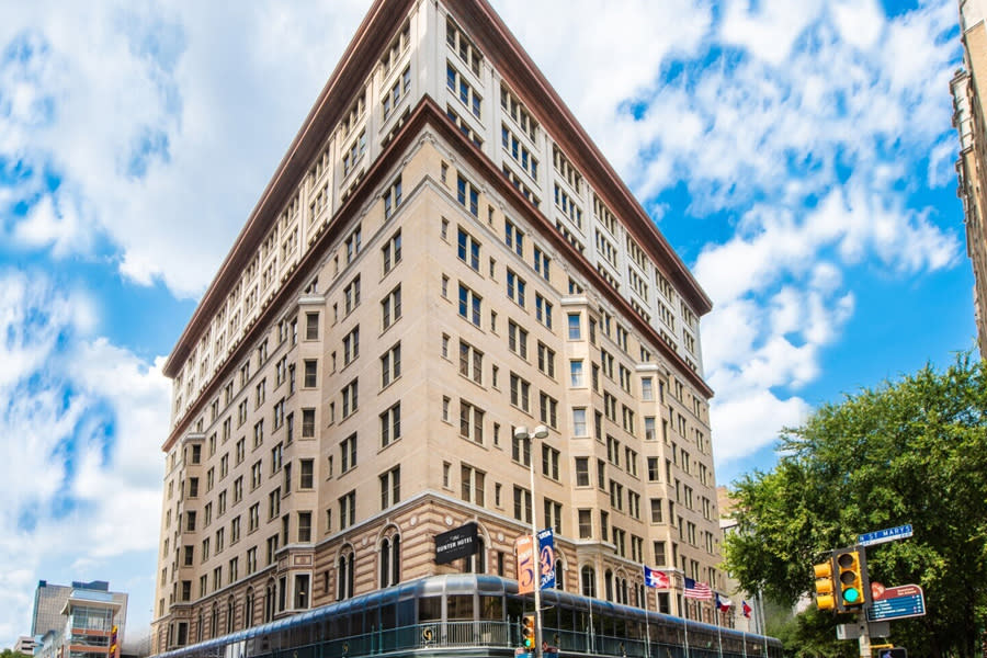 Angled hotel building with blue sky and fluffy clouds in background